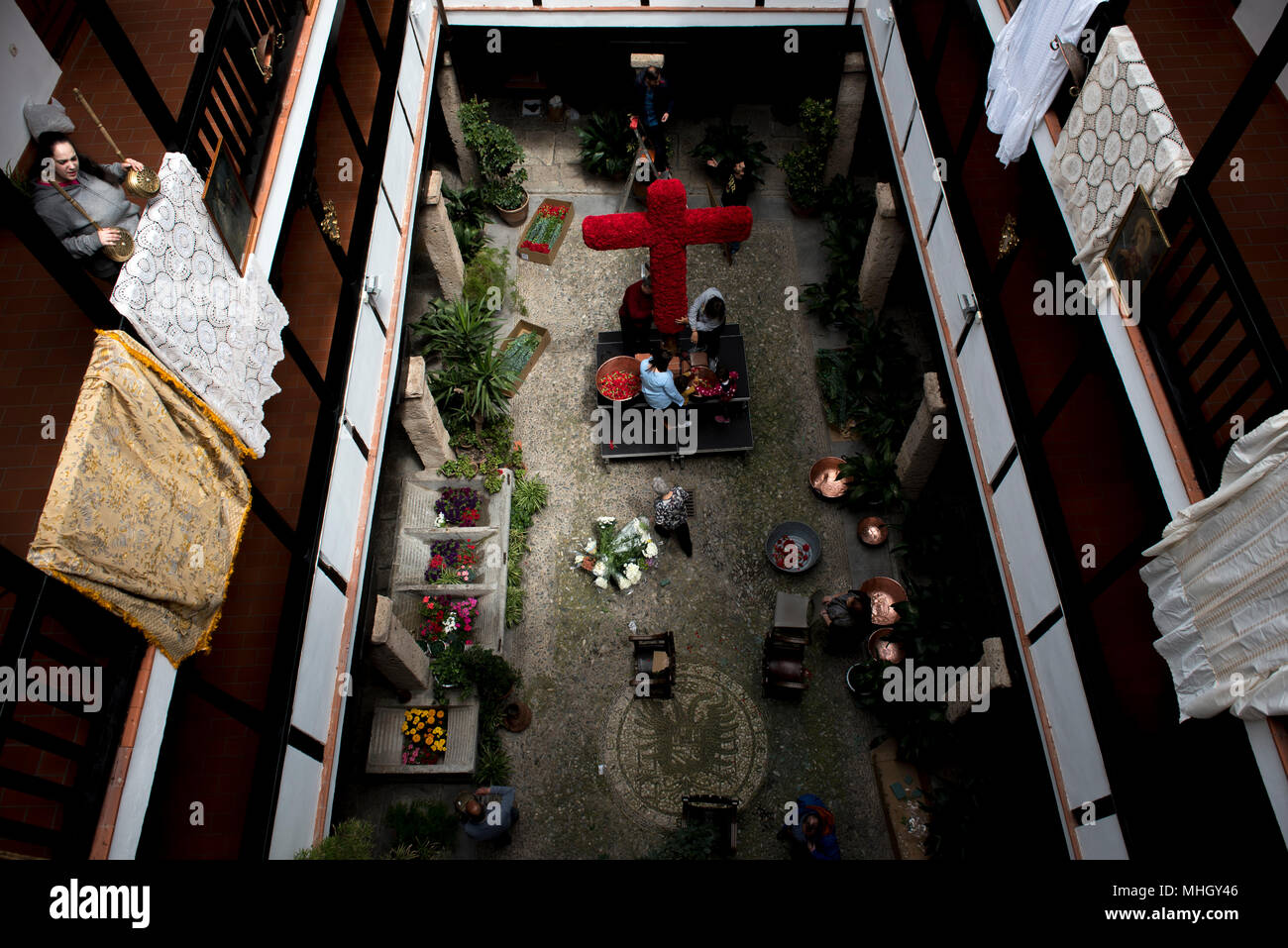 Persone nella terrazza dell 'corrala de Santiago' preparare l'altare con la croce per la imminente 'Dia de la Cruz'. "El Día de la Cruz" o "Día de las Cruces" è una delle più belle feste in Granada. Ogni 3 maggio molte vie, piazze e terrazze mostrano altari con croci ornate di fiori per commemorare la Santa Croce. Foto Stock