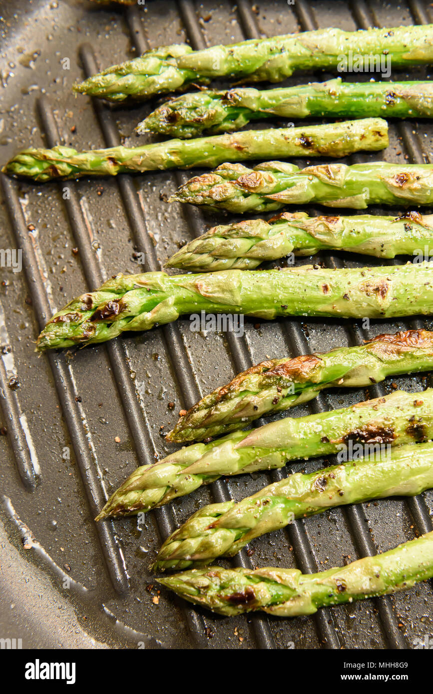 Asparagi freschi la cottura su piastra pan Foto Stock