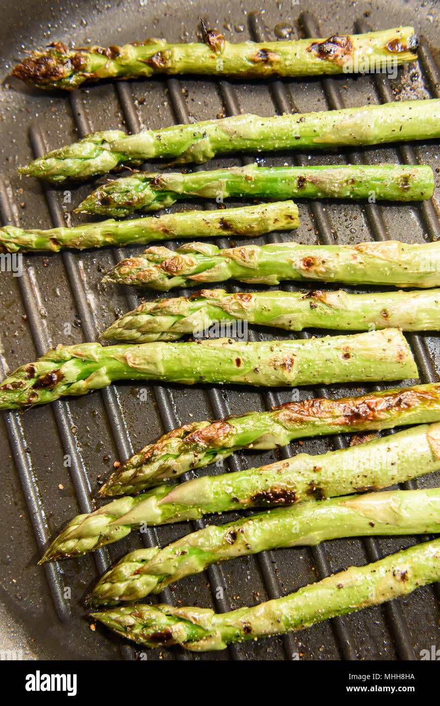 Asparagi freschi la cottura su piastra pan Foto Stock