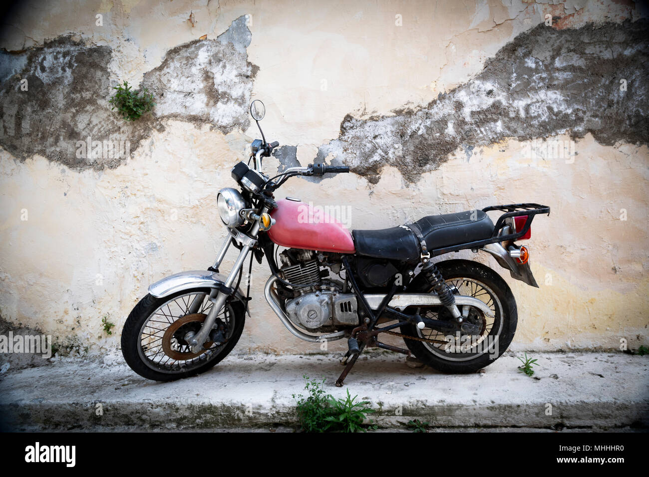 Vecchia moto contro un vecchio muro in Atene, Grecia Foto Stock Vecchia moto contro un vecchio muro in Atene, Grecia Foto Stock