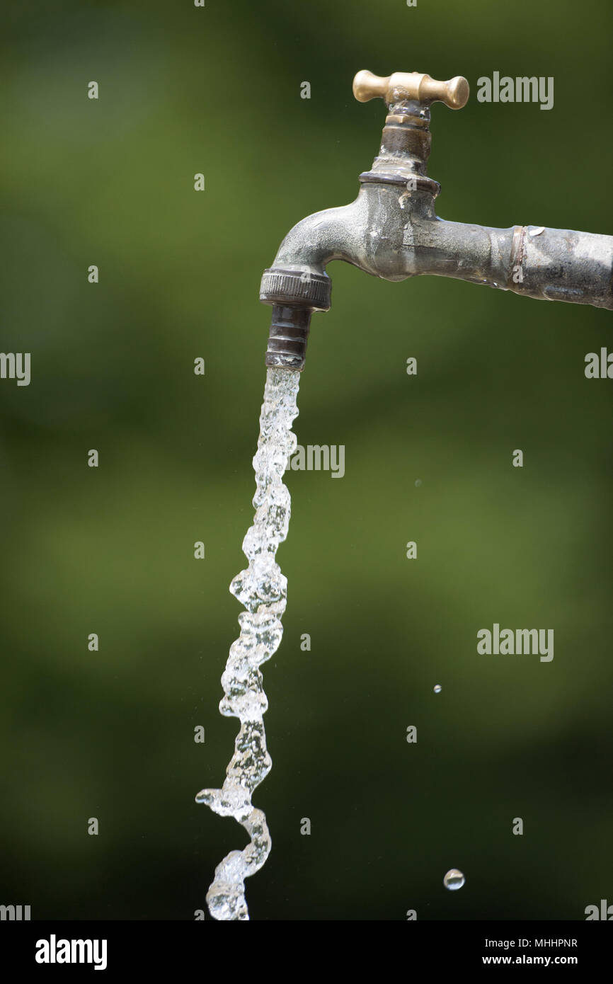 L'acqua che cade dal rubinetto aperto in campagna Foto Stock