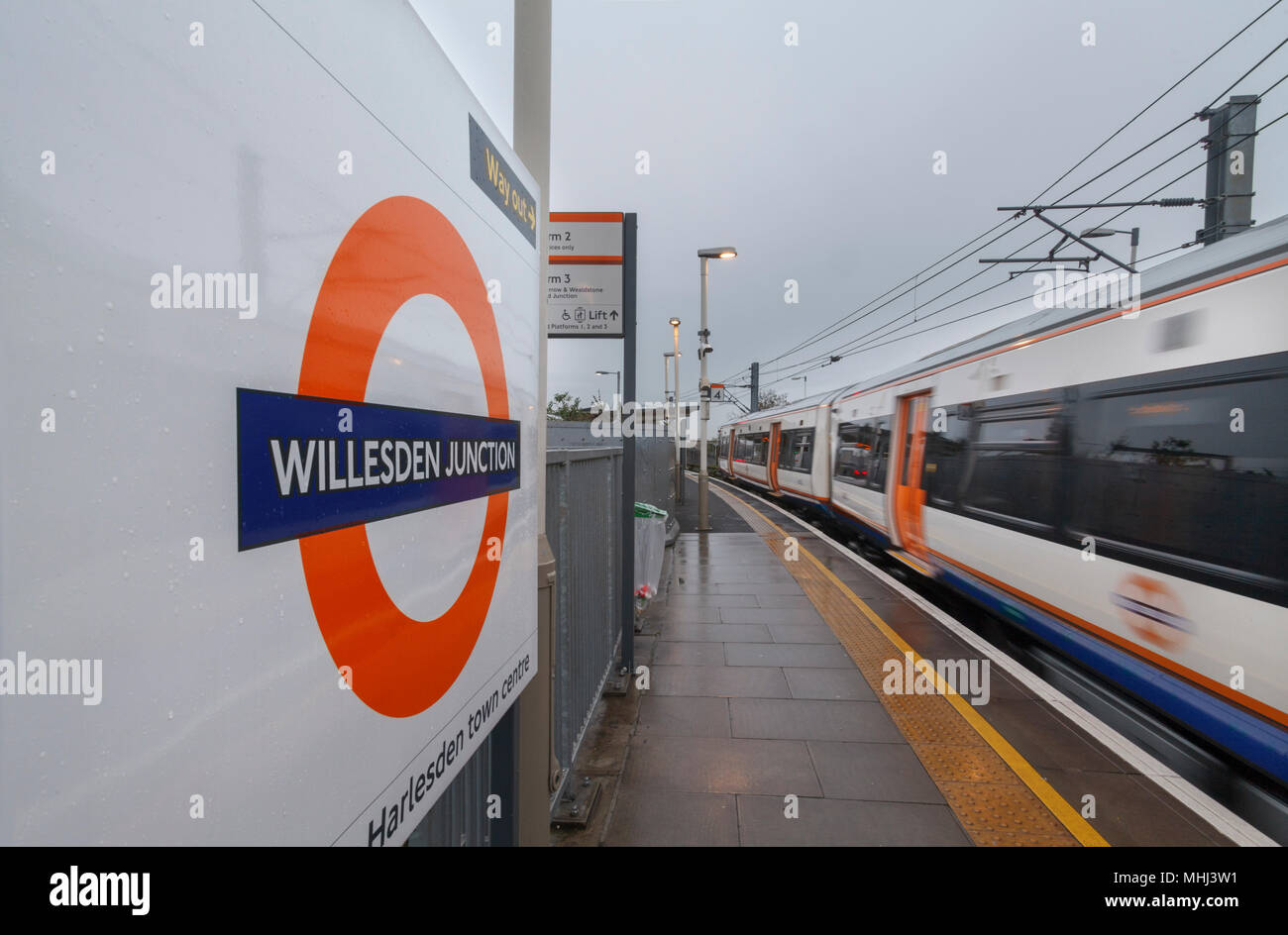 Un London Overground classe 378 stelle capitale treno Uscire Willesden Junctionn ad alto livello con il segno della stazione e il logo overground Foto Stock