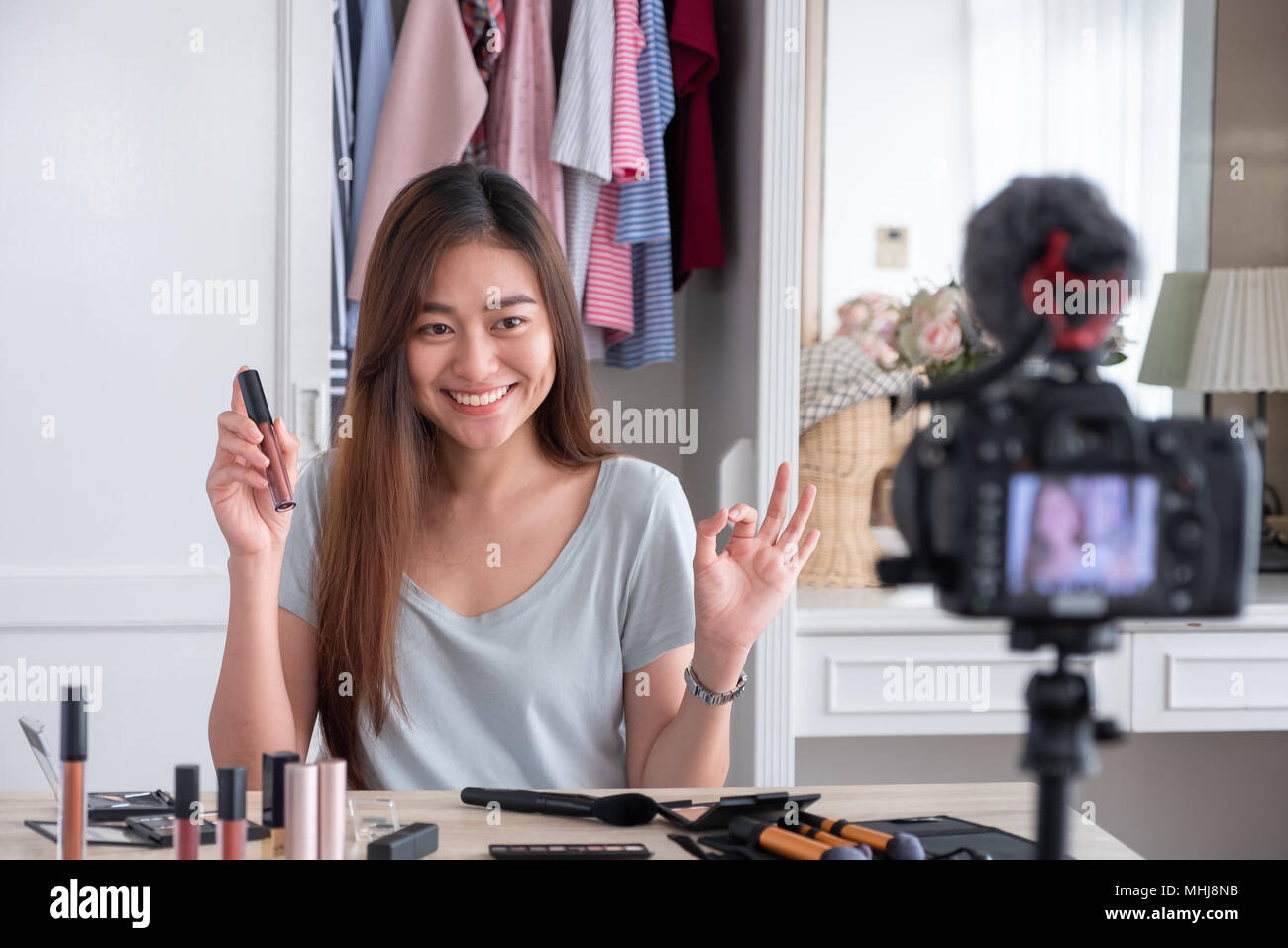 Asian giovane femmina blogger vlog di registrazione video con cosmetici per il trucco a casa consulente online su social media concetto.live streaming viral Foto Stock