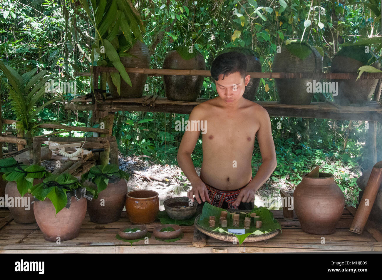 Servire il vino di riso in un Dusun casa di Mari Mari Villaggio Culturale, Kota Kinabalu, Sabah Malaysian Borneo Foto Stock