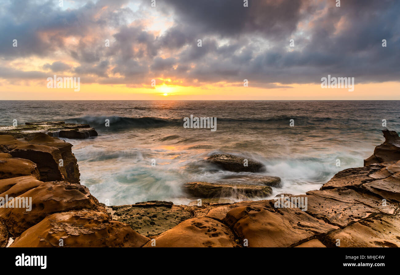 Rocky Sunrise Seascape - guardare il tramonto fino a North Avoca Beach, Avoca Beach, Central Coast, NSW, Australia. Foto Stock