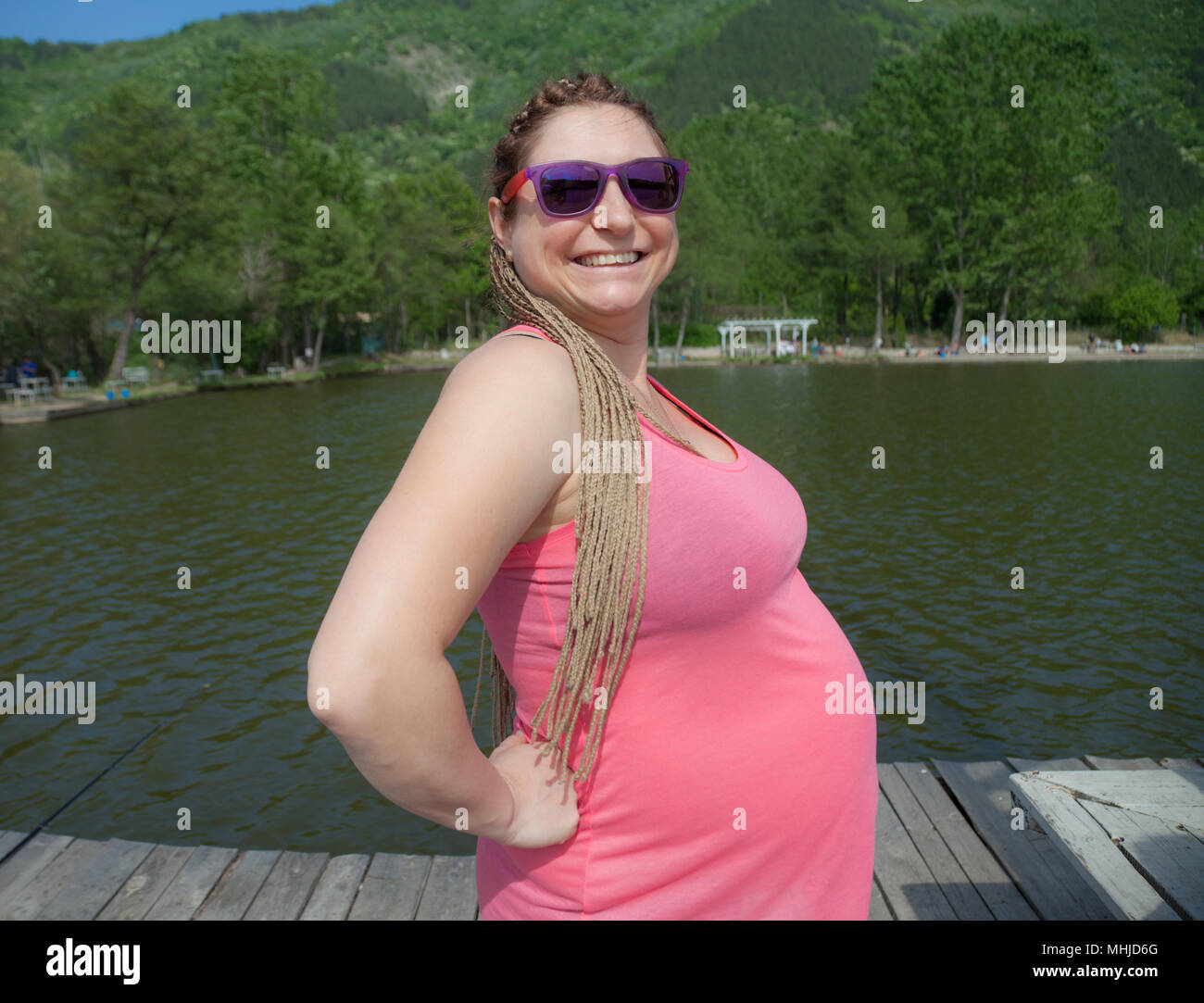 Felice donna incinta all'aperto Foto Stock