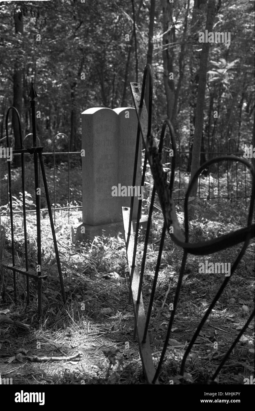 Rotture di lapidi e scherma piegate sono trovati in un trascurato cimitero confederate nei pressi di Fayetteville, Arkansas. Foto Stock
