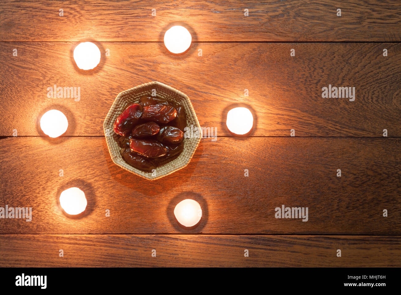 Table top visualizza immagine aerea di decorazione Ramadan Kareem holiday sfondo.piatto date di laici nel cestino di legno con attorno al bianco candela aromaterapia.Essent Foto Stock