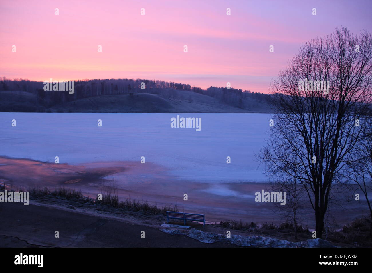 La vista dalla finestra sul ghiaccio coperta lago e montagna avanti in serata Foto Stock