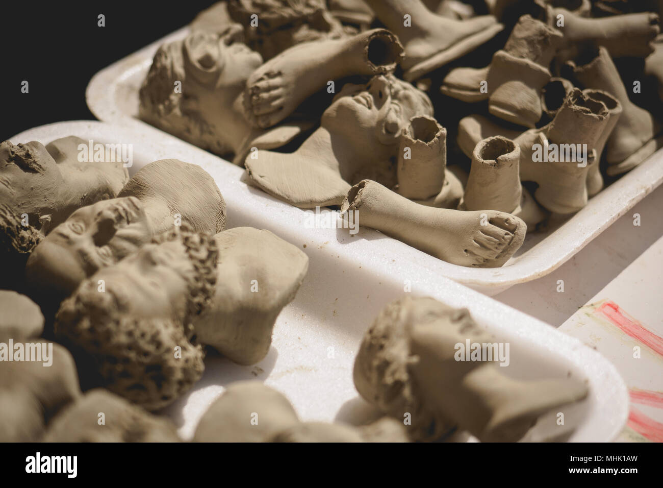 Corpo in terracotta le parti che devono essere assemblate per statue di scena della Natività e il presepe di Natale in un laboratorio artigiano di Napoli. Foto Stock