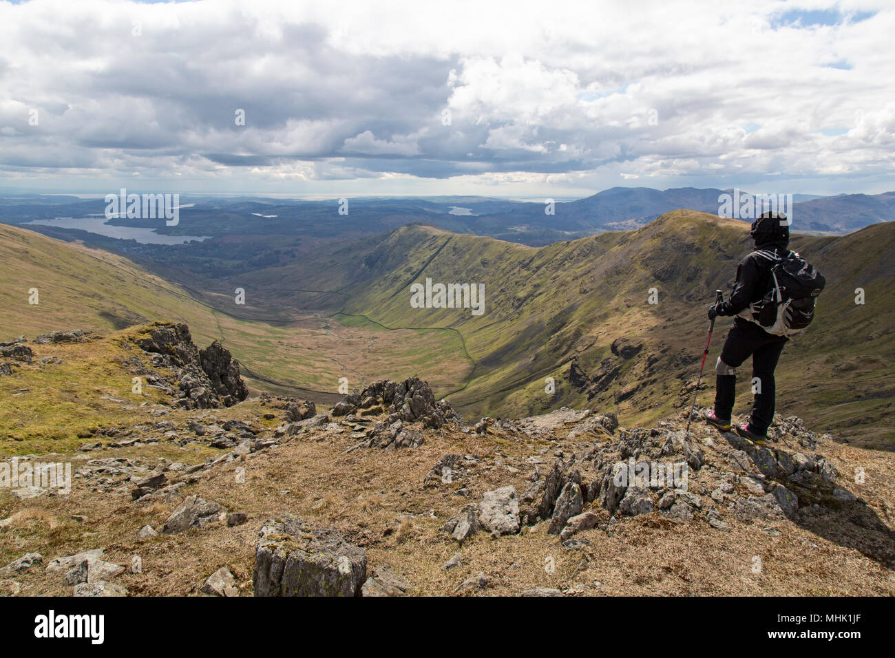 Una femmina di escursionista guardando verso le montagne del Fairfield Horseshoe trekking nel parco nazionale del Lake District in Inghilterra. Foto Stock