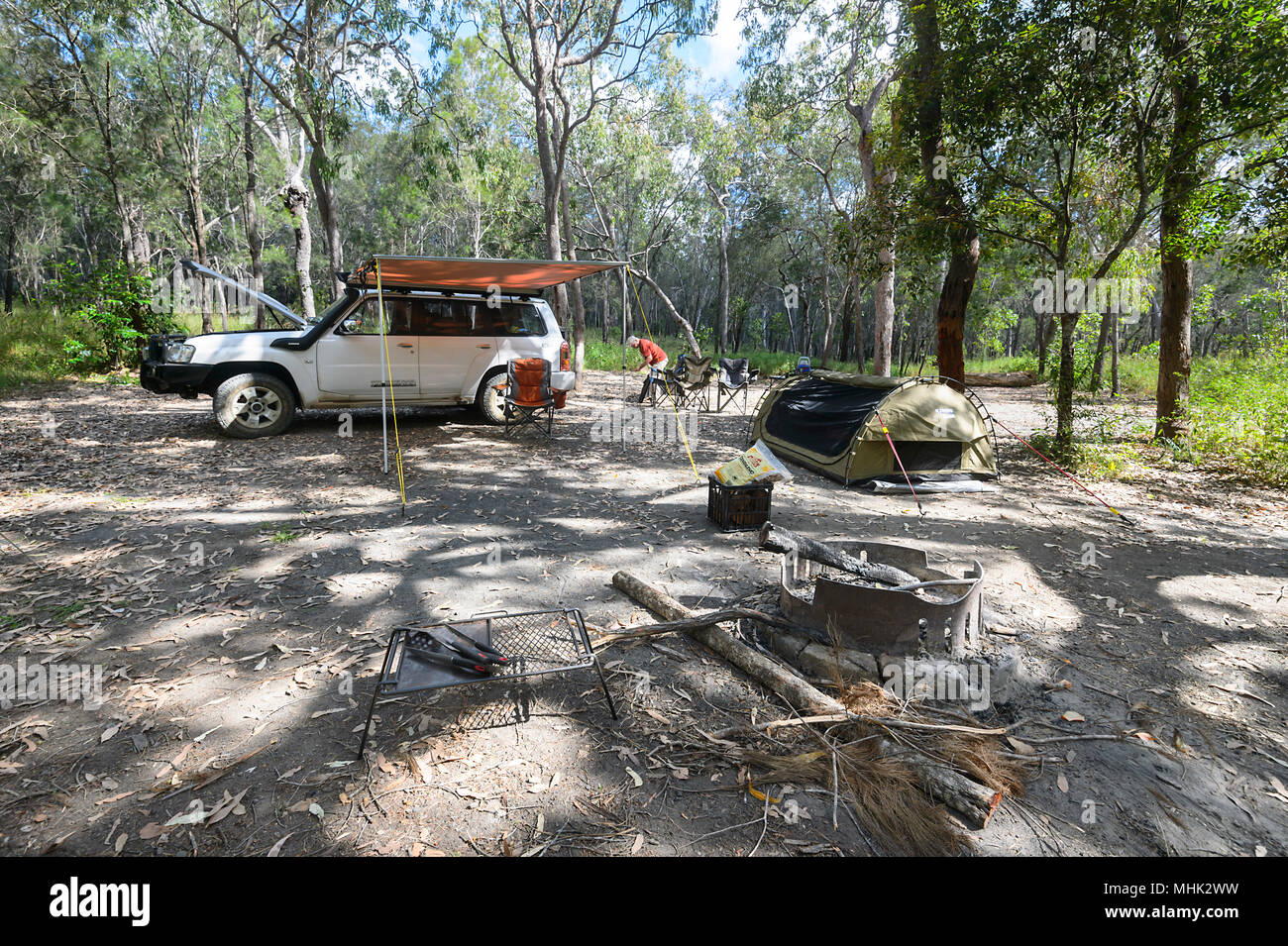 Un ombroso bushcamp con una Nissan Patrol 4x4 car, tenda, swag e anello di fuoco, Davies Creek National Park vicino a Mareeba Aeroporto, estremo Nord Queensland, FNQ, QLD, Au Foto Stock