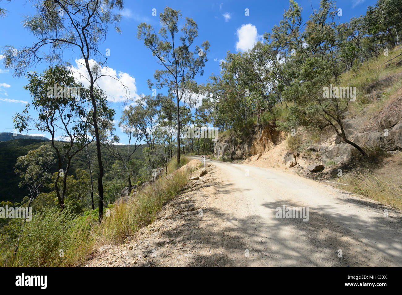Vista di un avvolgimento stretto in salita su strada sterrata attraverso Davies Creek National Park vicino a Mareeba Aeroporto, estremo Nord Queensland, FNQ, QLD, Australia Foto Stock