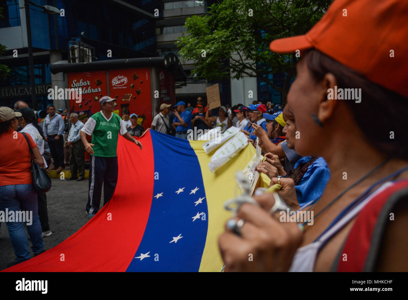 Caracas, Venezuela. Il 1 maggio 2018. I manifestanti visto tenendo un grande bandiera venezuelana durante la dimostrazione. Lavoratori e dirigenti sindacali hanno protestato nella città di Caracas per migliori salari e condizioni di lavoro migliori. Nei giorni precedenti il presidente della Repubblica del Venezuela, Nicolas Maduro ha decretato un minimo di aumento salariale che è ancora al di sotto del tasso di inflazione del paese e che non coprono i bisogni della classe operaia. Credito: SOPA Immagini limitata/Alamy Live News Foto Stock