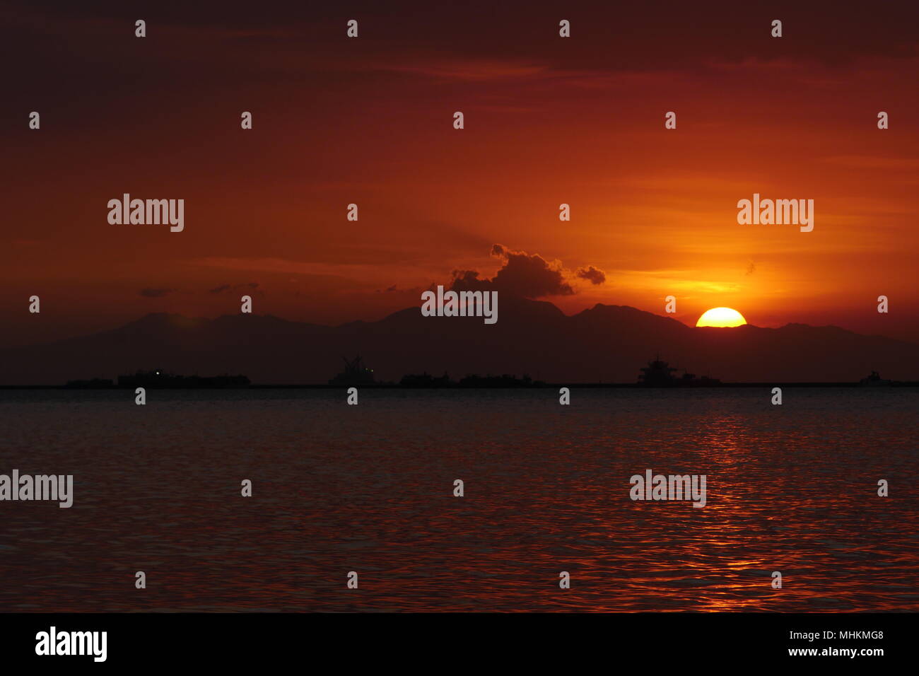 Manila, la regione della capitale nazionale, Filippine. 28 apr, 2018. La gente guarda il tramonto come esso scompare dal calore del giorno.i tramonti e scompare al Monte Natib che è su Bataan. Credito: George Buid/ZUMA filo/Alamy Live News Foto Stock