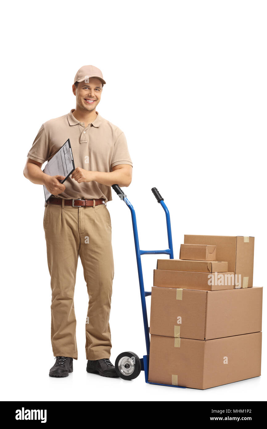 A piena lunghezza Ritratto di un uomo di consegna con un fermaglio poggiante su un carrello con una pila di scatole isolate su sfondo bianco Foto Stock