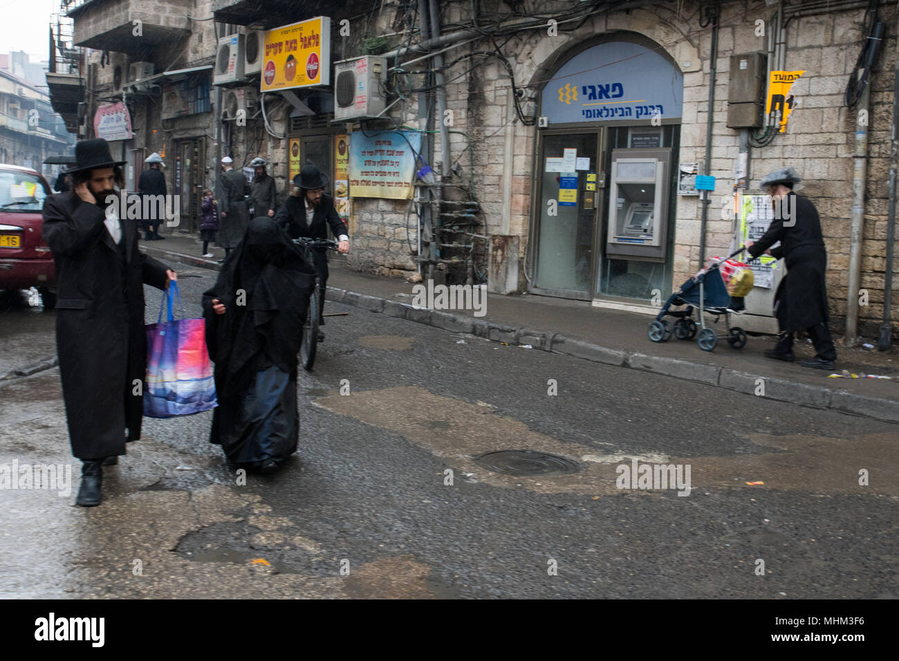 Gerusalemme, Israele. Il 30 marzo, 2018. Una giovane donna di Haredi burqa setta a piedi a Mea Shearim quartiere con un uomo vestito come un Haredi. Foto Stock