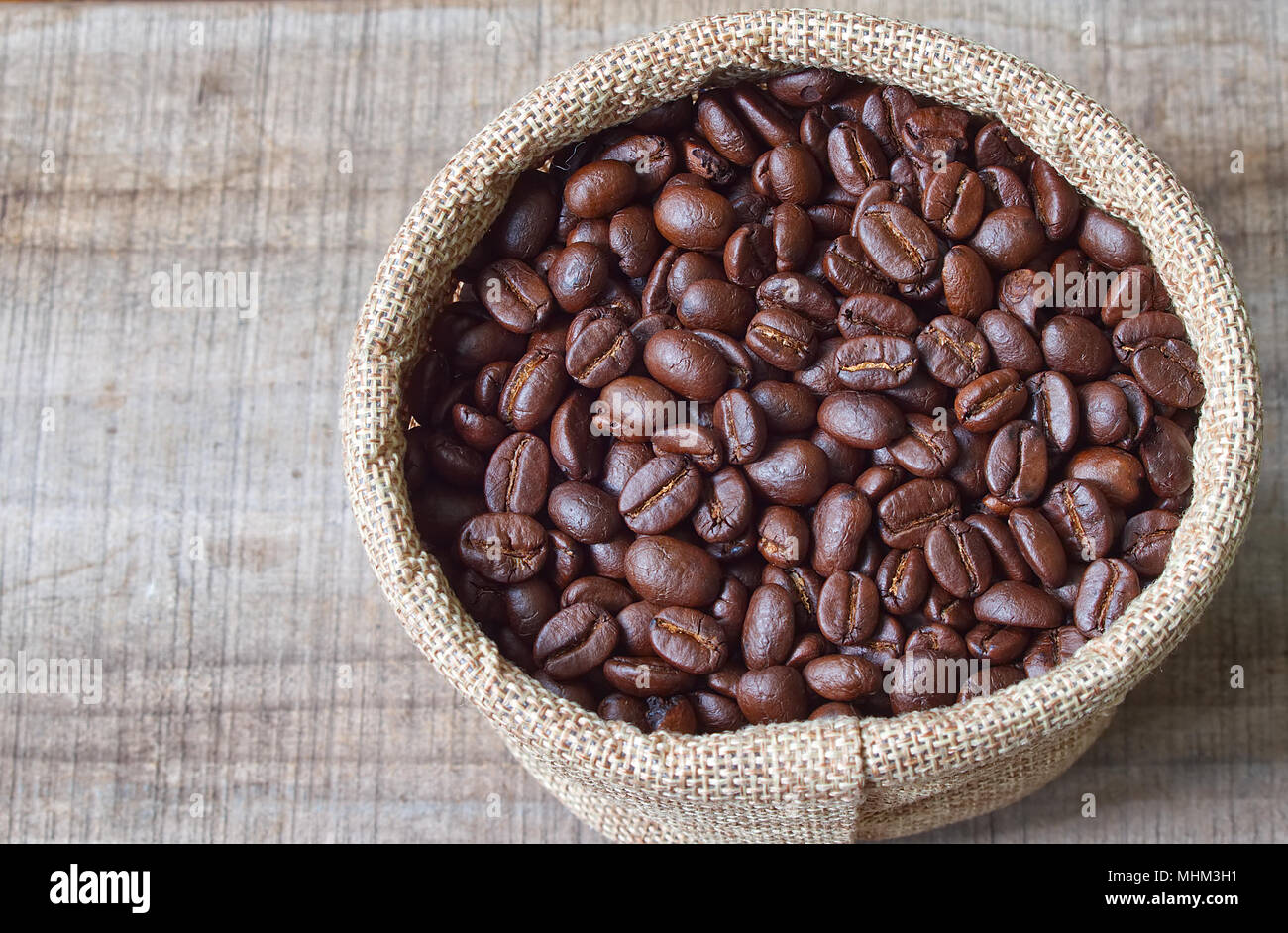 Topview i chicchi di caffè in borsa sul tavolo di legno. Foto Stock