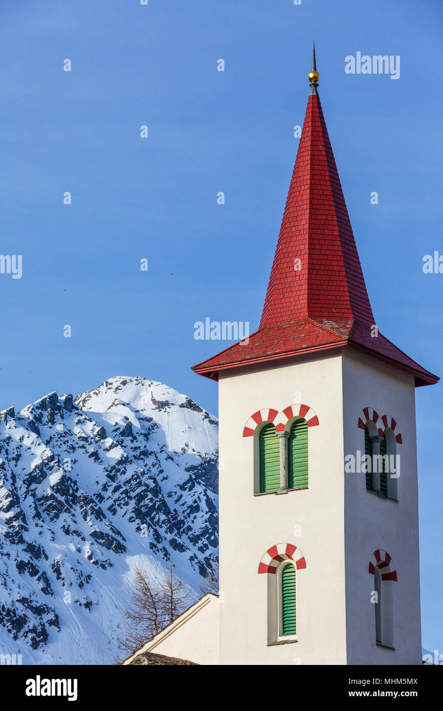 Torre della chiesa telai le cime innevate su una giornata di primavera Maloja Pass Cantone dei Grigioni Svizzera Europa Foto Stock