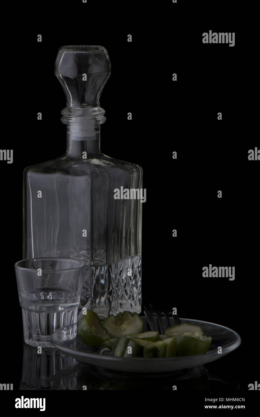 Vodka, cetrioli, colpo di vetro su uno sfondo nero con una forcella Foto Stock