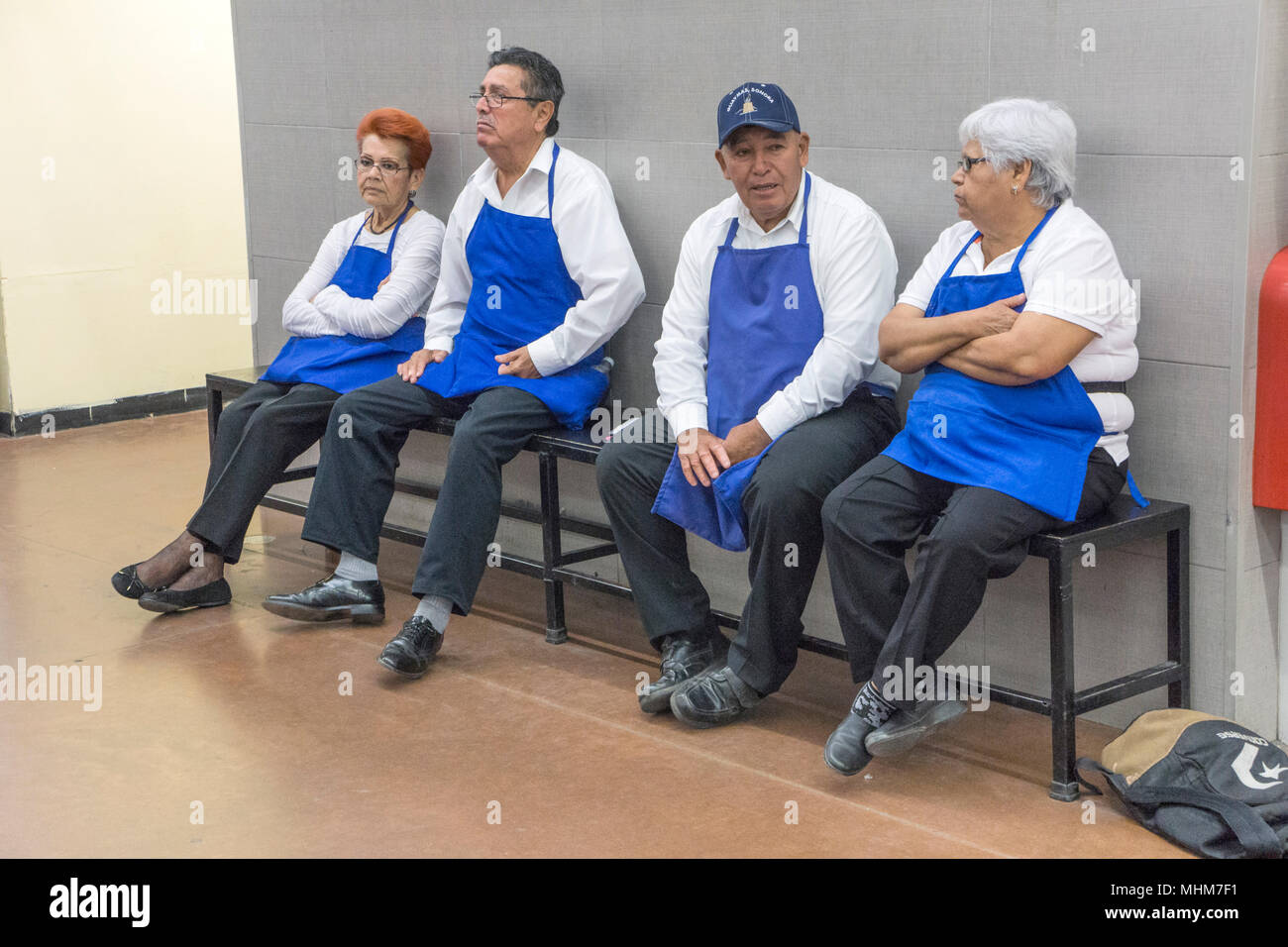 4 I membri di noi catena negozio uniformata team insaccatrice che assistono i cassieri per suggerimenti prendere pausa seduta sul banco di lavoro rilassante all'interno di chat Walmart messicano Foto Stock