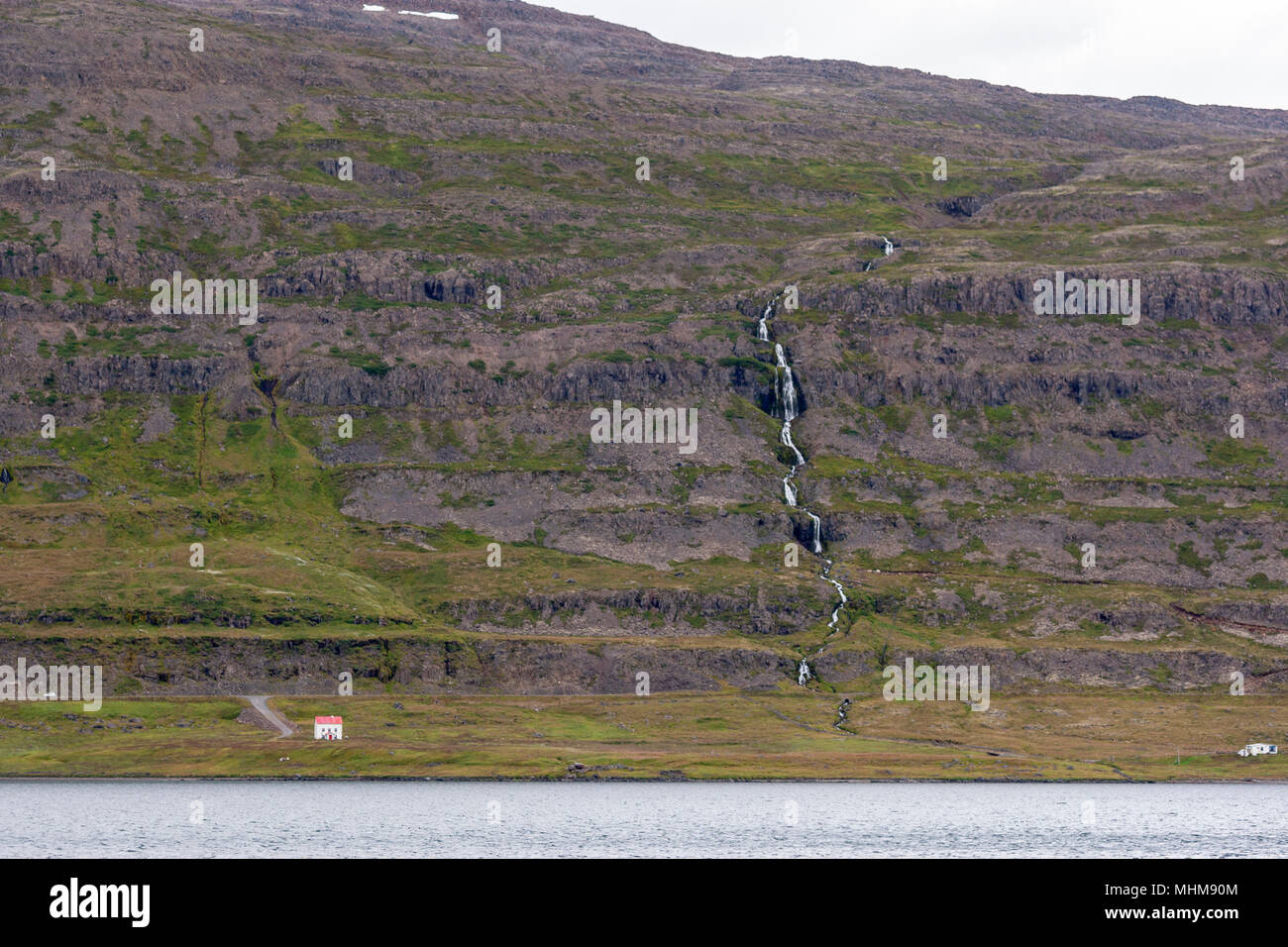 Casa isolata nei pressi di una cascata dal percorso 61, Regione Westfjords, Islanda Foto Stock