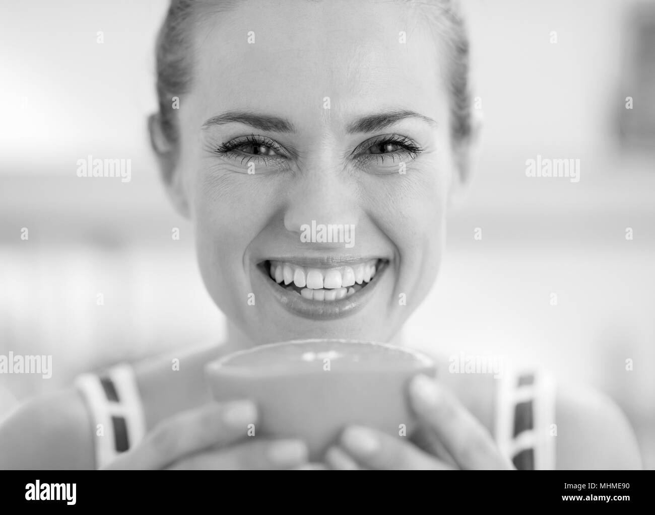 Sorridente giovane donna azienda fetta di arancia Foto Stock