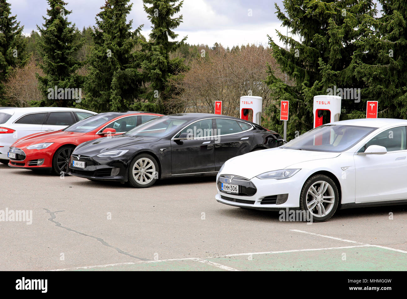 Tre Tesla Model S le auto elettriche sono di carica della batteria su un sovralimentatore station su un giorno di primavera in Paimio, Finlandia - 28 aprile 2018. Foto Stock