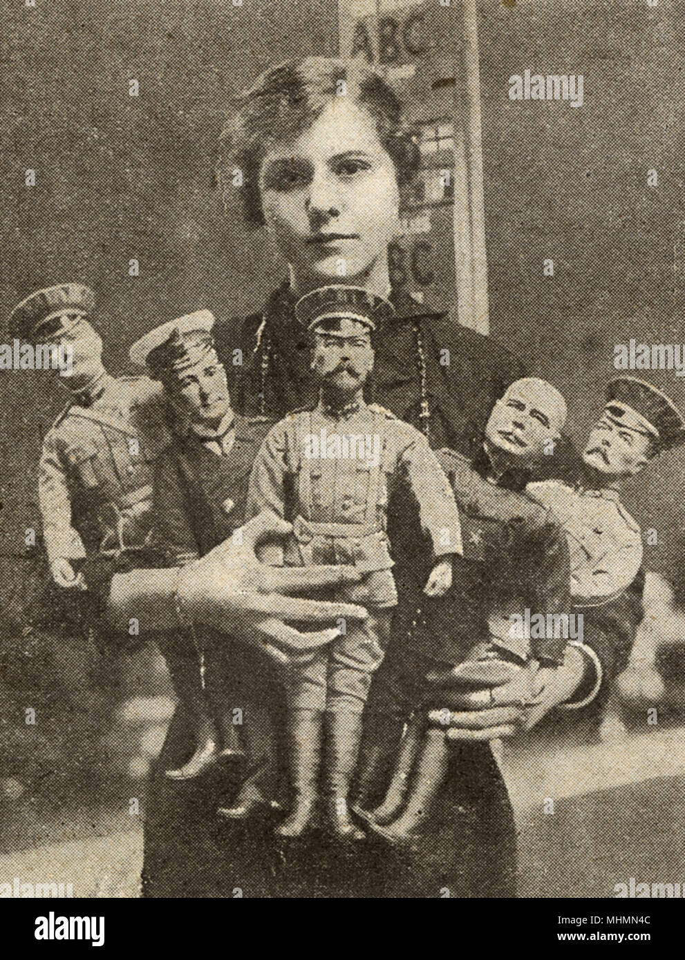 Un lavoratore di sesso femminile che hanno posato con la guerra bambole raffiguranti il Re, Lord Kitchener, Sir John francese, Sir John Jellicoe e il generale Joffre. Una selezione di British-giocattoli realizzati durante la Prima Guerra Mondiale. Prima della guerra Germania era stata il principale fornitore di giocattoli per la Gran Bretagna, ma l'industria britannica velocemente adattato, che impiega molte donne nel processo. Data: 1915 Foto Stock