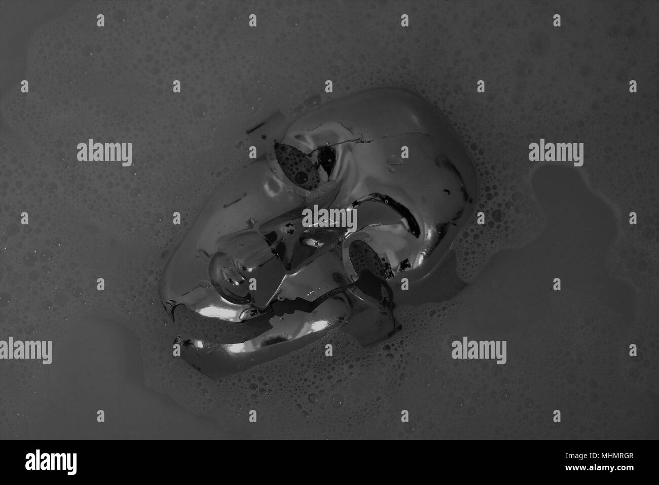 Abstract & Backgrounds - B&W in plastica maschera viso galleggianti in acqua. (Tema tainted spettacoli - Inquinamento plastico ) Foto Stock
