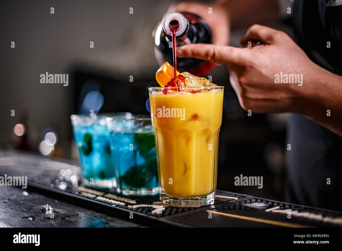 Il barista è la preparazione di cocktail arancione sul bancone del bar Foto Stock