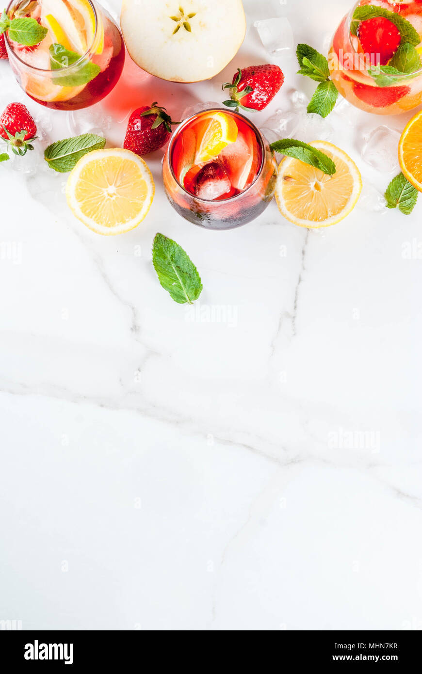Bianco freddo, rosa e rosso sangria cocktail con frutta fresca e bacche e foglie di menta. Foto Stock