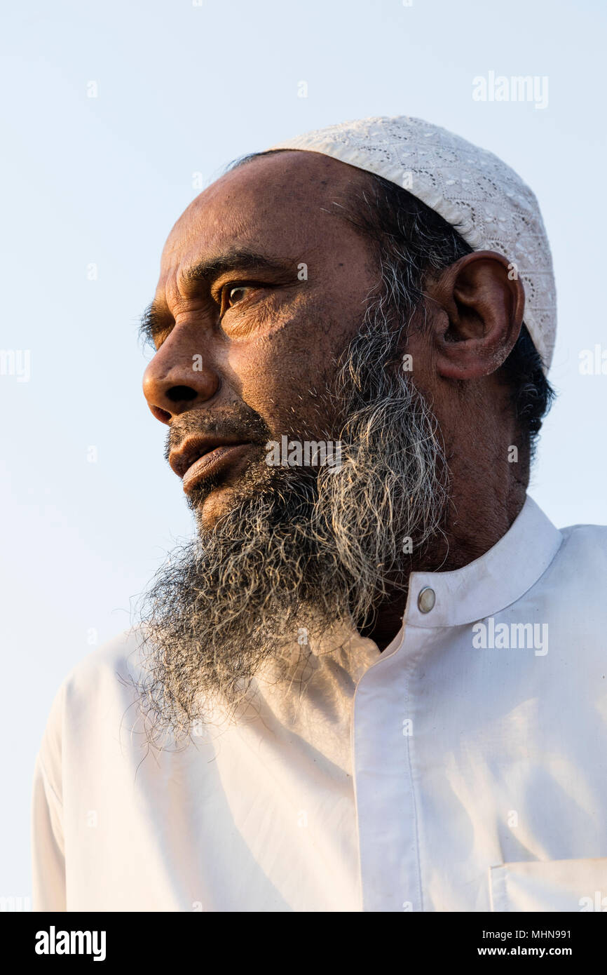 Dacca in Bangladesh, 24 Febbraio 2017: il vecchio musulmano con la barba e il tappo presa dal basso contro la luce-cielo blu Foto Stock