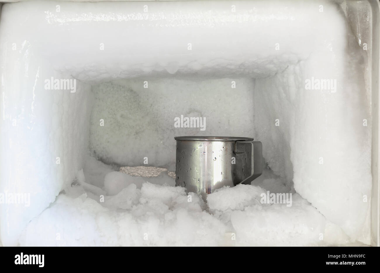 Acciaio inossidabile acqua potabile vetro nel congelatore di un  frigorifero. L'accumulo di ghiaccio all'interno di un congelatore pareti  Foto stock - Alamy
