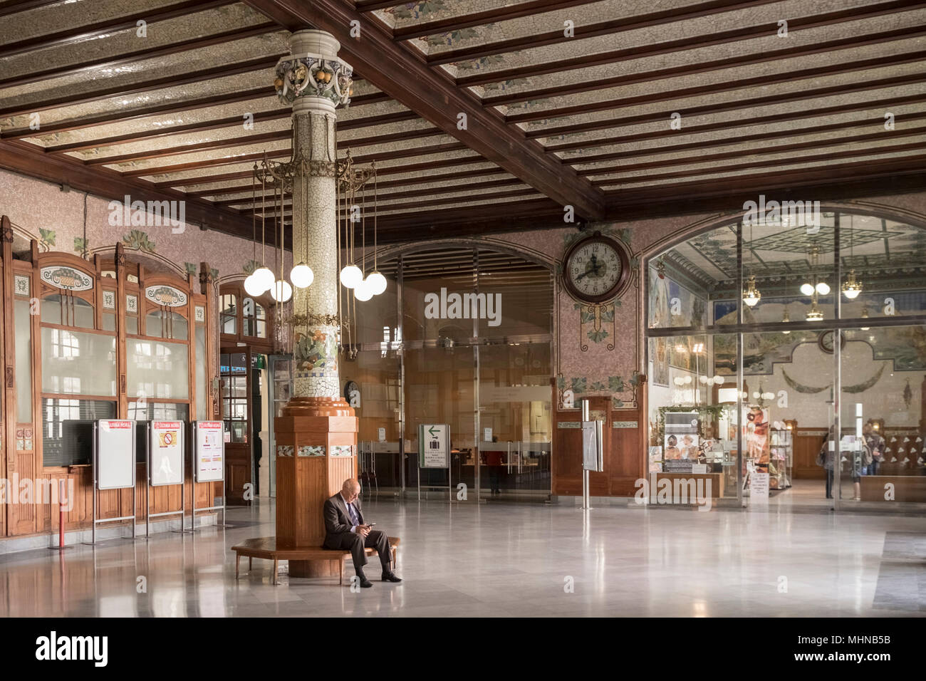 Un uomo anziano si siede da solo in attesa in interni ornati di Estacion del Norte (Nord Station), Sud Ciutat Vella distretto, Valencia, Spagna Foto Stock