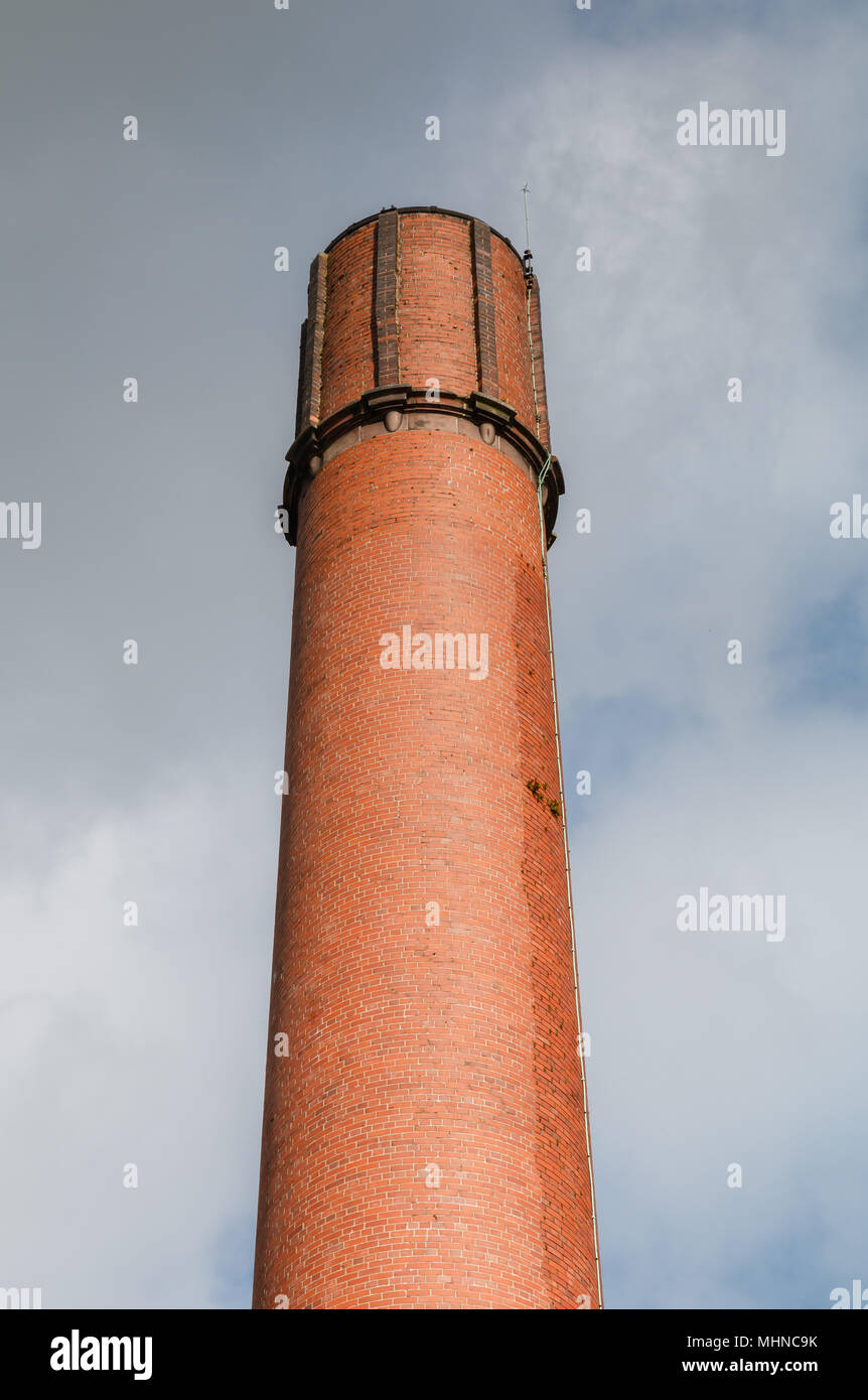 Mattone rosso mulino o camino in fabbrica contro un cielo tempestoso. Parte di nel mulino industriale complesso in Bollington Cheshire Foto Stock