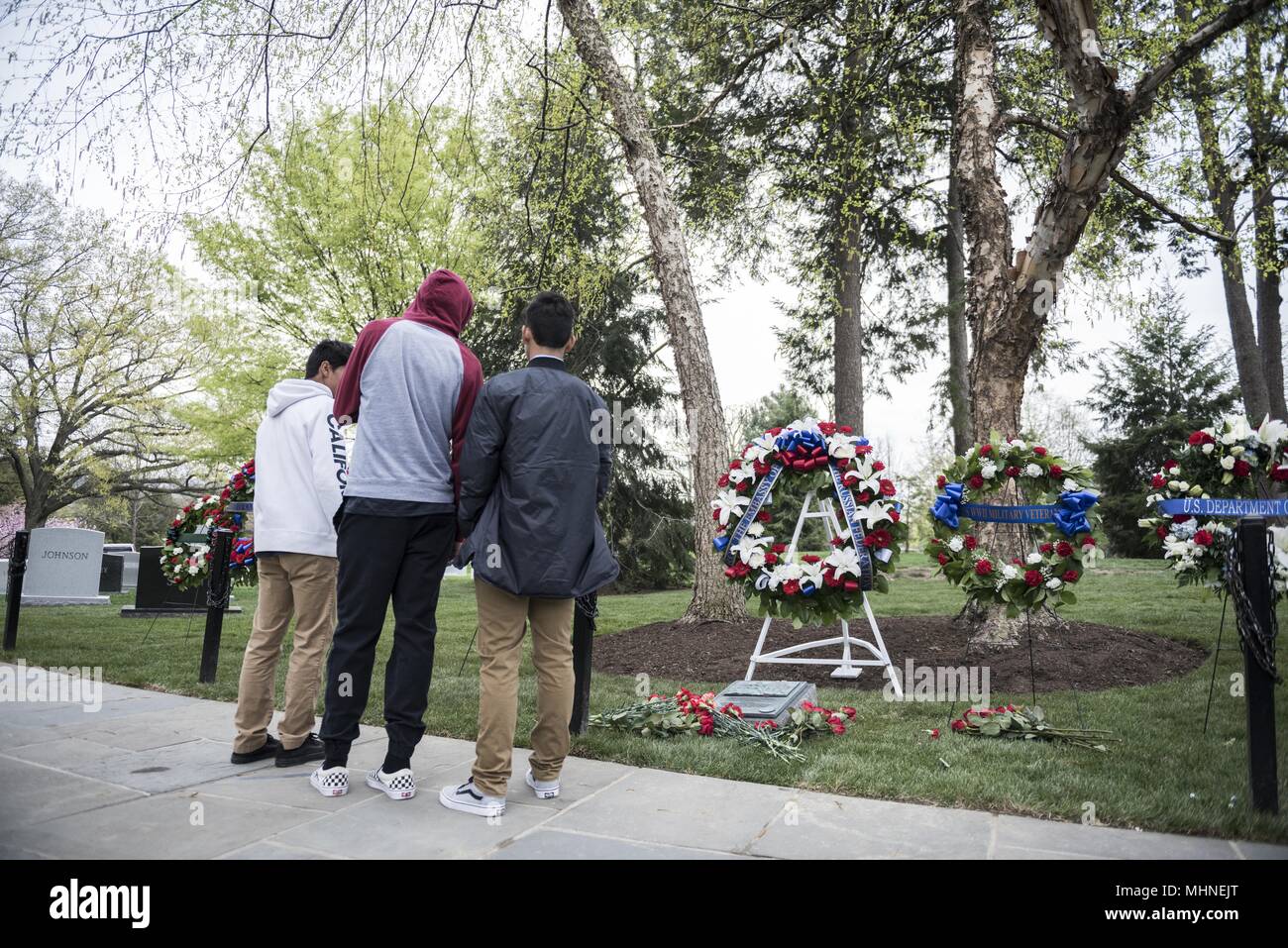 Visitatori frequentare una ghirlanda di cerimonia di posa mediante lo Spirito dell'Elba marcatore nella sezione 7A di il Cimitero Nazionale di Arlington Arlington, Virginia, 24 aprile 2018, 24 aprile 2018. Il marcatore di legge, "in riconoscimento della cooperazione da parte americana, Sovietici e le forze armate alleate durante la Seconda Guerra Mondiale. Questo marcatore simboleggia il collegamento di sovietico e americano degli elementi al fiume Elba il 15 aprile 1945. In omaggio al partenariato nella battaglia contro la tirannia. ' (Esercito degli Stati Uniti foto di Elizabeth Fraser / il Cimitero Nazionale di Arlington / rilasciato). () Foto Stock