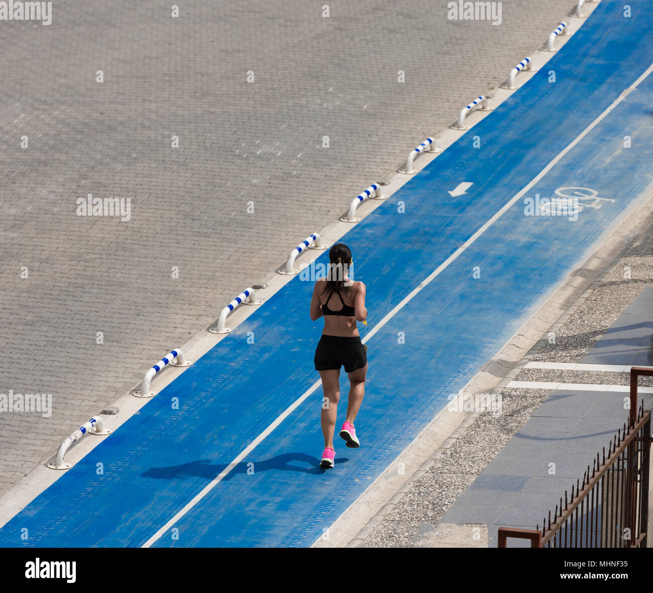 Lady in esecuzione sul percorso per biciclette Foto Stock