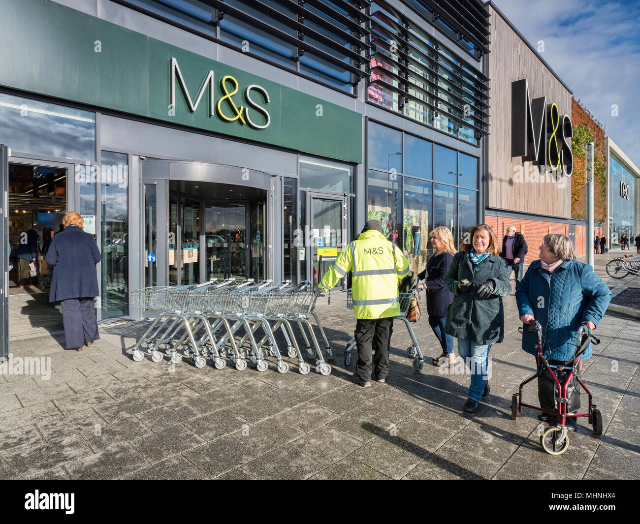 2 febbraio 2018: York, Regno Unito - Un M&S dipendente in una alta vis vest, che lavorano al di fuori del negozio alla Vangarde Shopping Centre, i monaci Croce e sho femmina Foto Stock