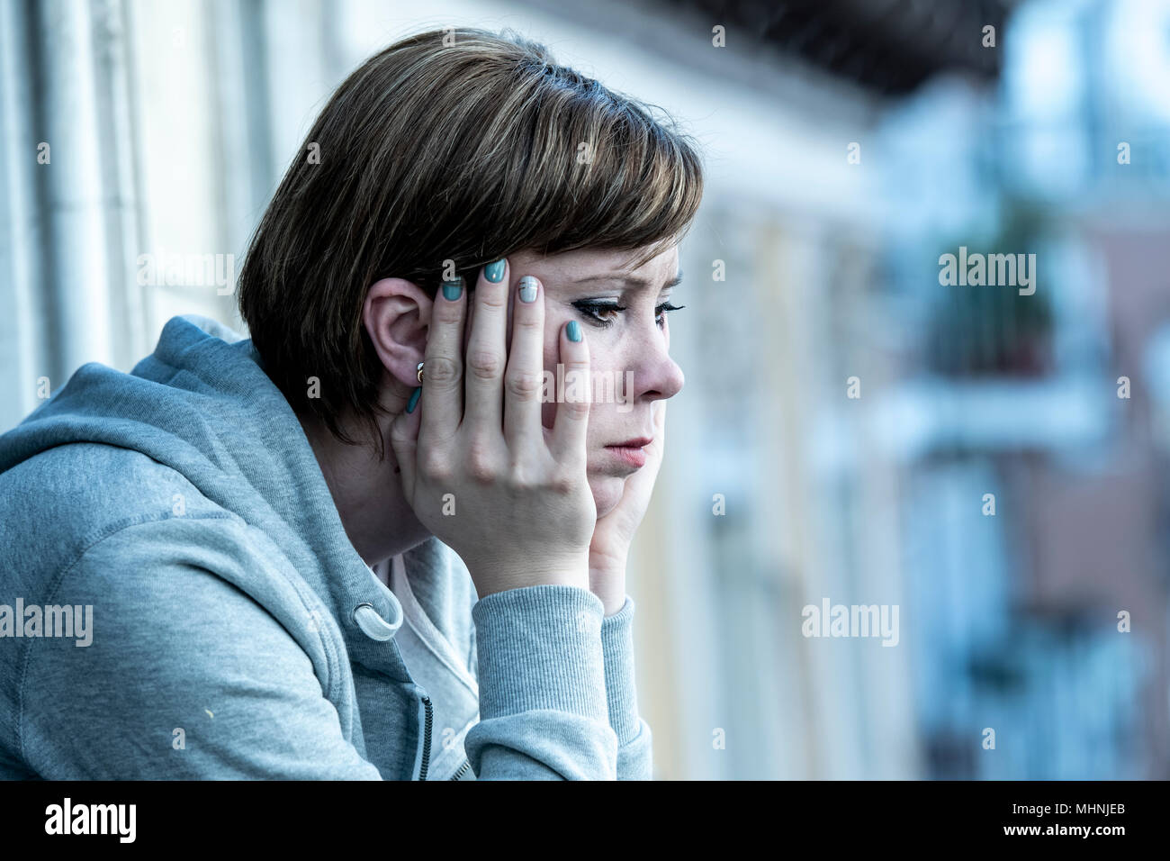 Giovani belle, infelice, depresso e solitario caucasica cercando triste sul balcone di casa. sensazione di miserabili e disperata. Adulti in stile di vita Foto - Alamy