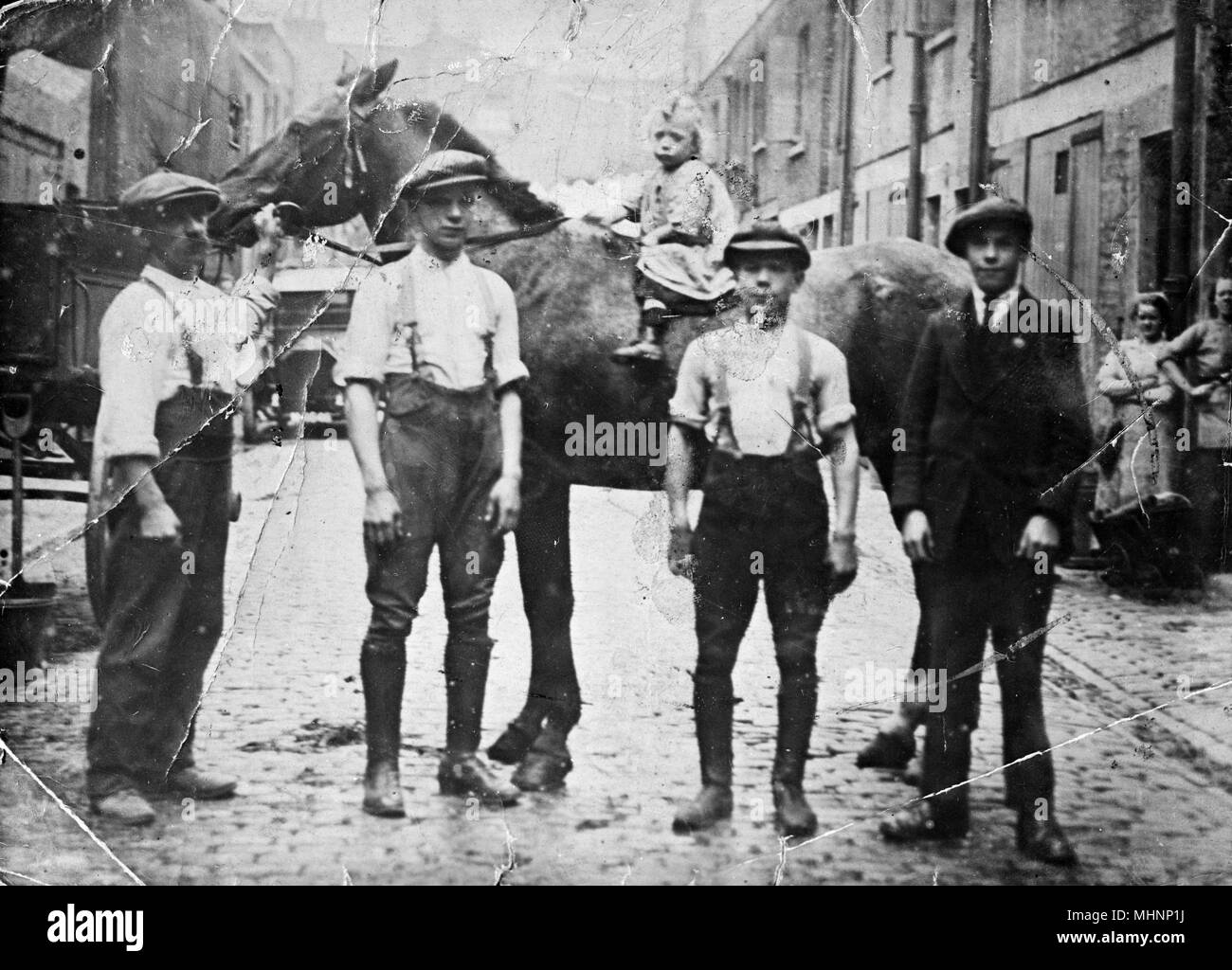 Famiglia con cavalli, Huntsworth Mews, Marylebone, London -- uomo e tre ragazzi e un bambino seduto su un cavallo. Data: circa 1910 Foto Stock