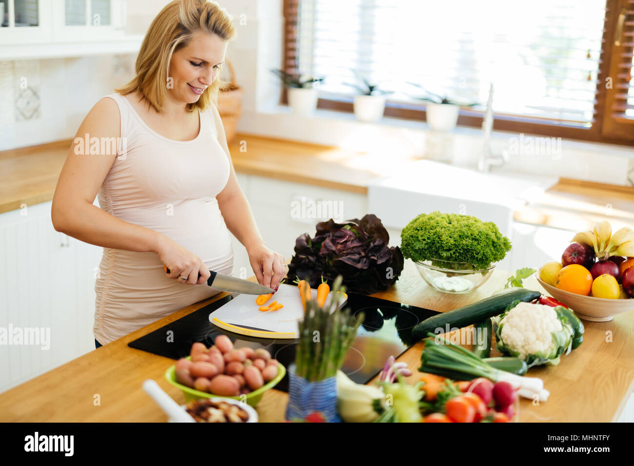 Bella donna incinta la preparazione di pasto Foto Stock