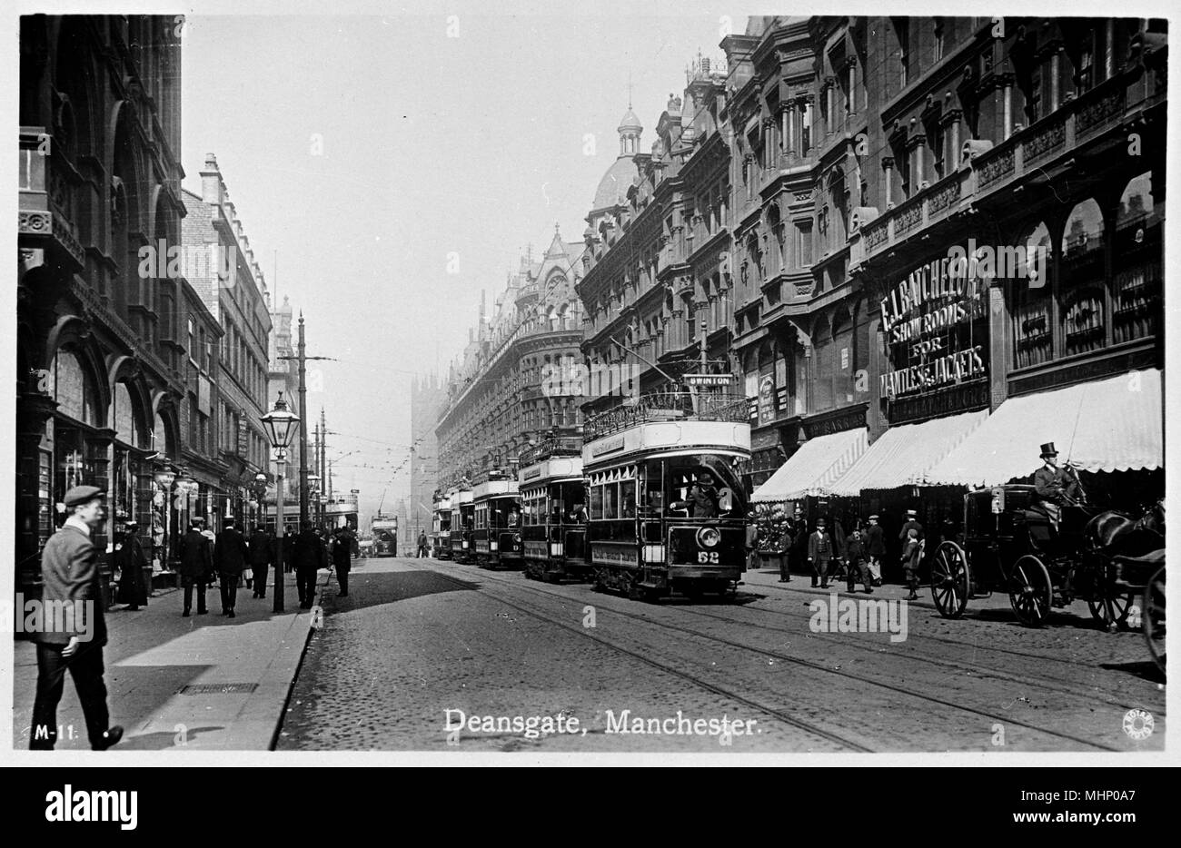 Deansgate, Manchester, con una linea di tram al centro e la Batchelor showroom sulla destra. Data: circa 1920s Foto Stock
