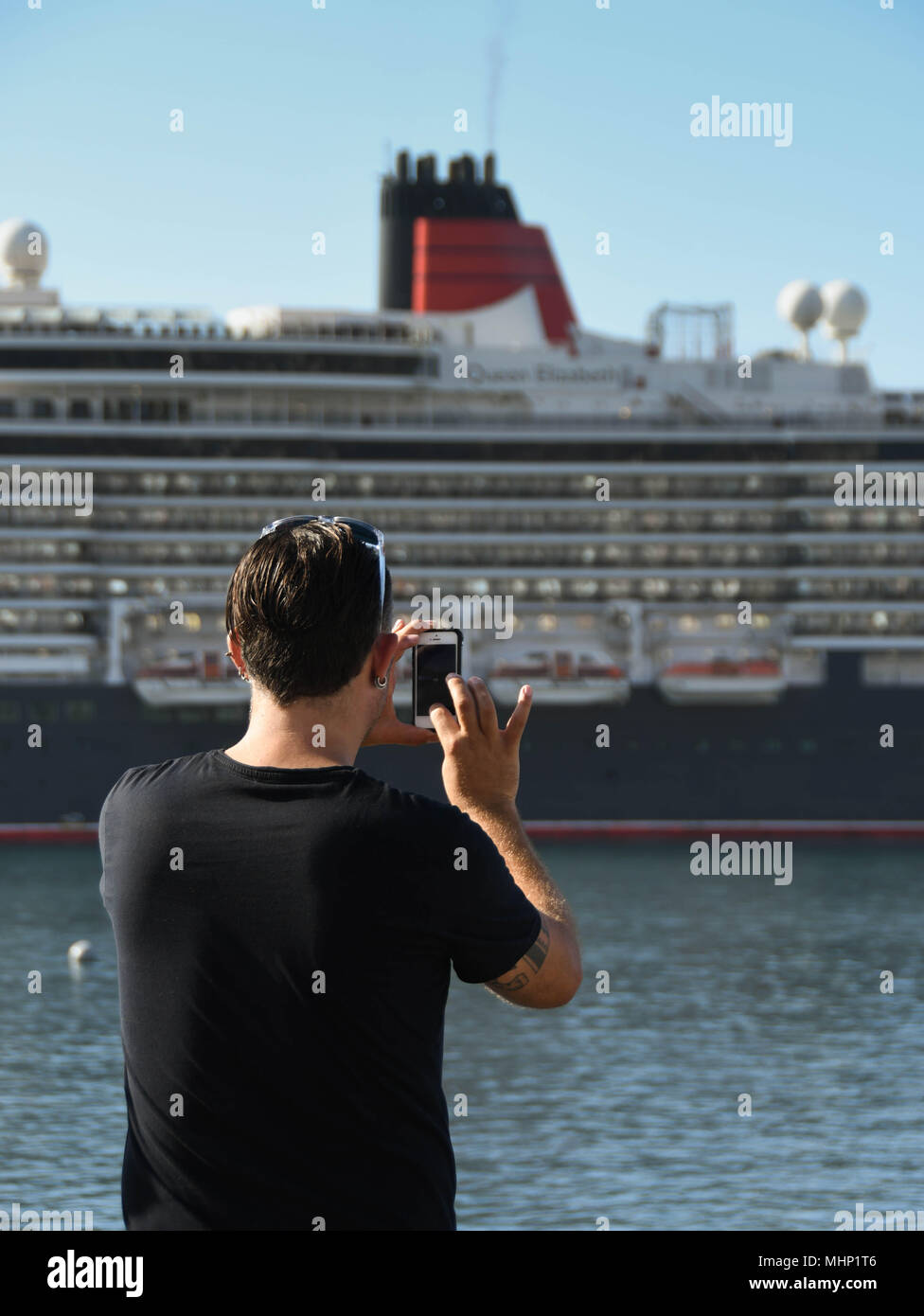 Persona di scattare una foto della nave da crociera Queen Elizabeth nel porto di Funchal, Madeira Foto Stock