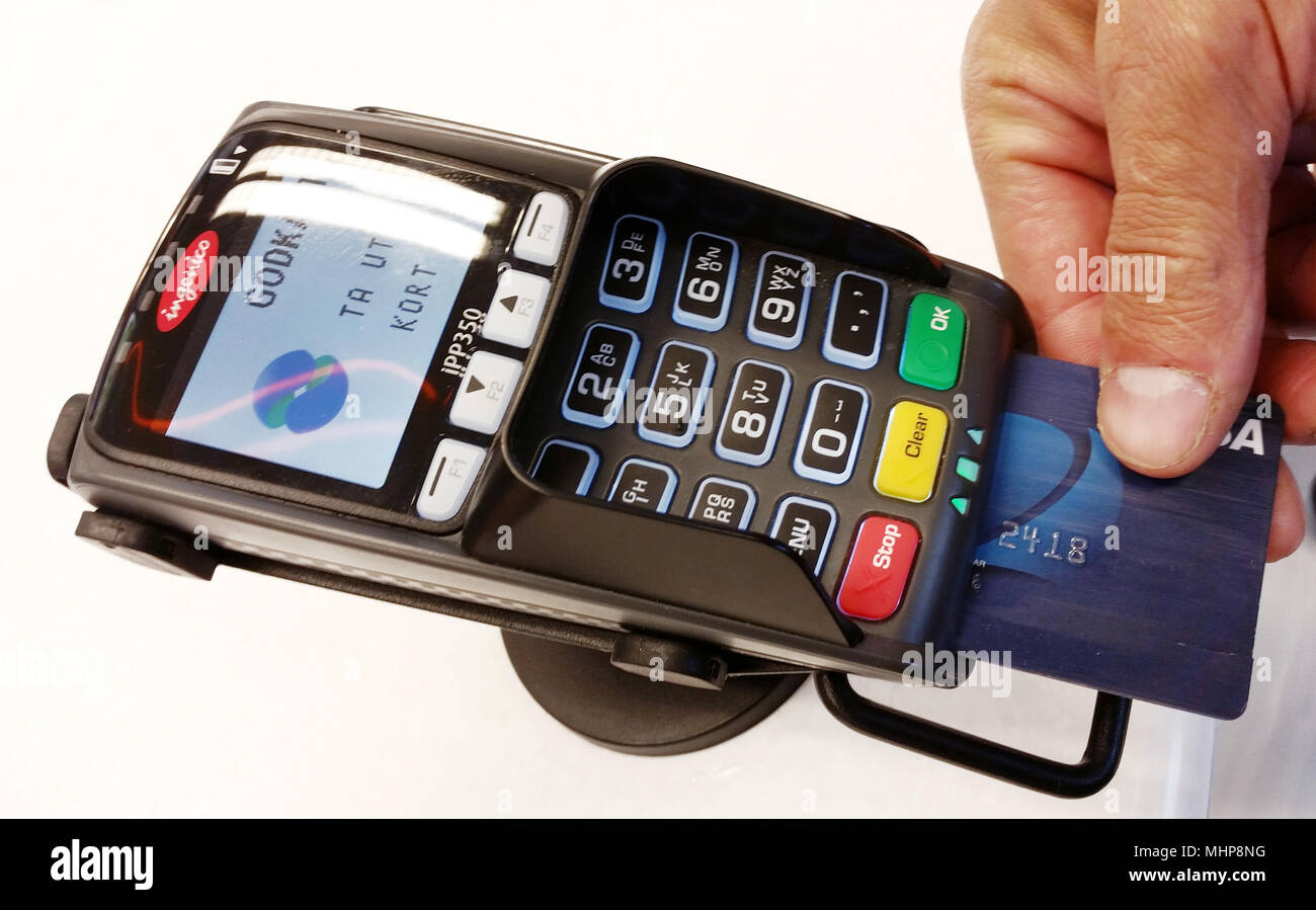 Haparanda, Svezia - Luglio 9, 2015: Una mano umana azienda utilizzando una carta di credito in un lettore di carte di pagamento.lettore di carte di credito, Foto Stock