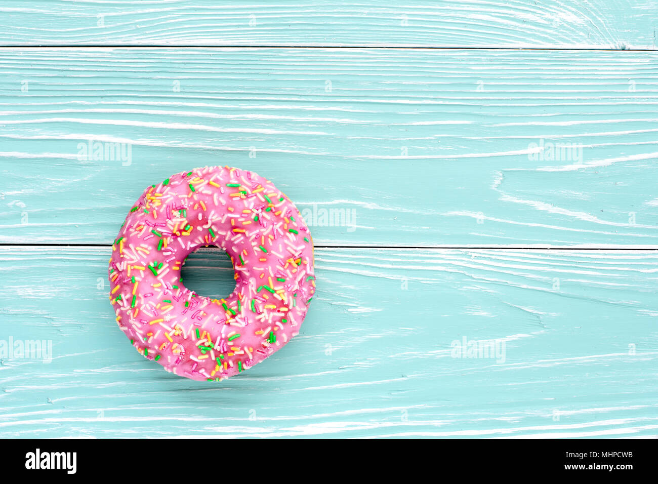 Ciambella rosa blu su sfondo di legno. Vista dall'alto. Copiare lo spazio per testo, logo e design Foto Stock