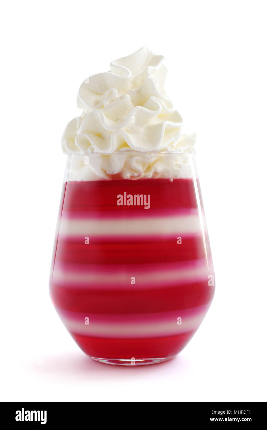 Red striped jella dessert in vetro con panna montata in cima isolata su sfondo bianco Foto Stock