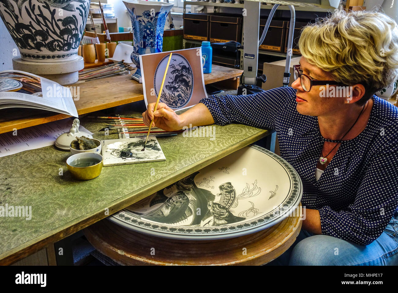 Manifattura Porcellane Meißen, donna pittura piatto porcellana in un laboratorio di arte in Sassonia, Meissen ceramica Germania Foto Stock