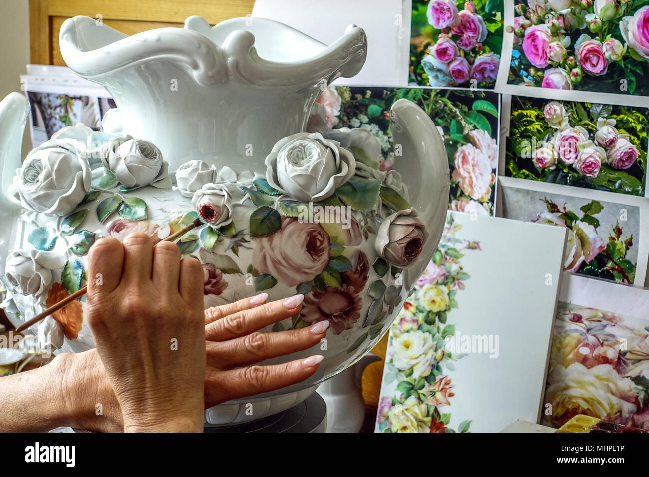 Fabbrica di porcellana per officina Meissen, donna decora vaso di porcellana Sassonia, vaso Meissen Germania Foto Stock