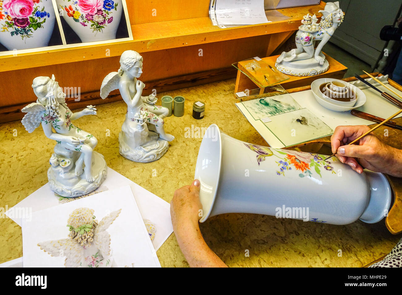 Meissen vaso in porcellana e Cupido in un laboratorio d'arte, donna pittura on-glaze porcellana Meissen Germania produzione Foto Stock